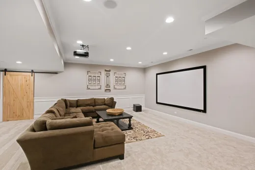Finished basement home theatre with a large screen, a space where ceiling soundproofing pays off in both directions