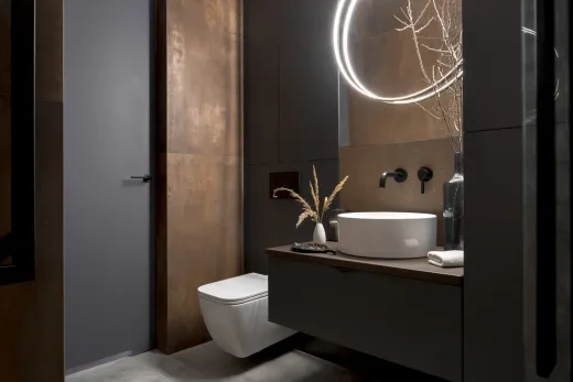 Compact powder room with a custom vanity and statement fixtures after renovation