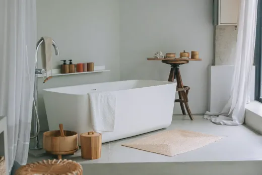 Freestanding soaker tub in a renovated bathroom, positioned clear of the walls as the room's centrepiece