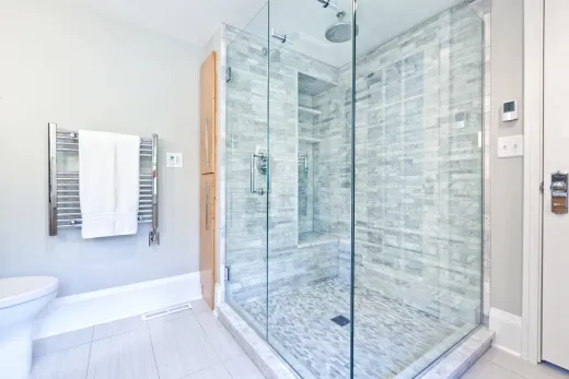 Marble-tiled walk-in shower built on proper waterproofing — the step most failed bathrooms skipped
