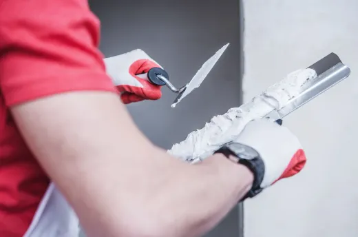 Tradesperson applying joint compound to a drywall seam with a taping knife