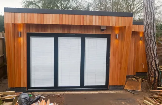 Garden suite under construction on site, framing stage — the work a prefab module replaces in a factory
