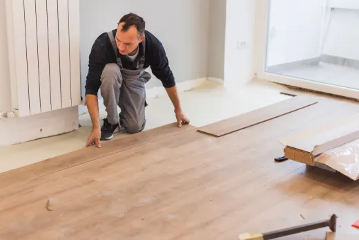 Carpenter fitting hardwood floorboards during a GTA home renovation
