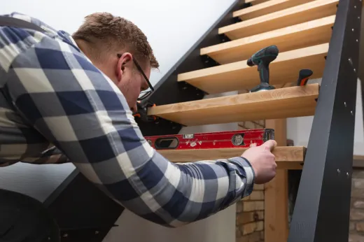Carpenter installing new stair treads during a Mississauga staircase renovation