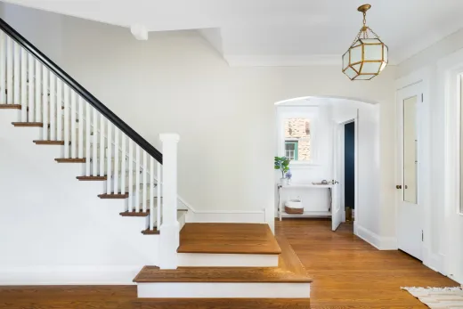 Renovated foyer staircase with new railing and modern light fixture