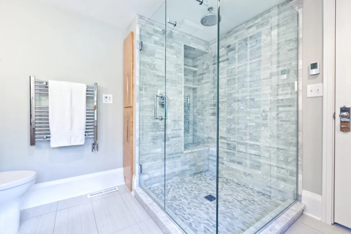 Luxury bathroom renovation with custom walk-in shower, marble tile walls, frameless glass enclosure, and spa-like design in Ontario