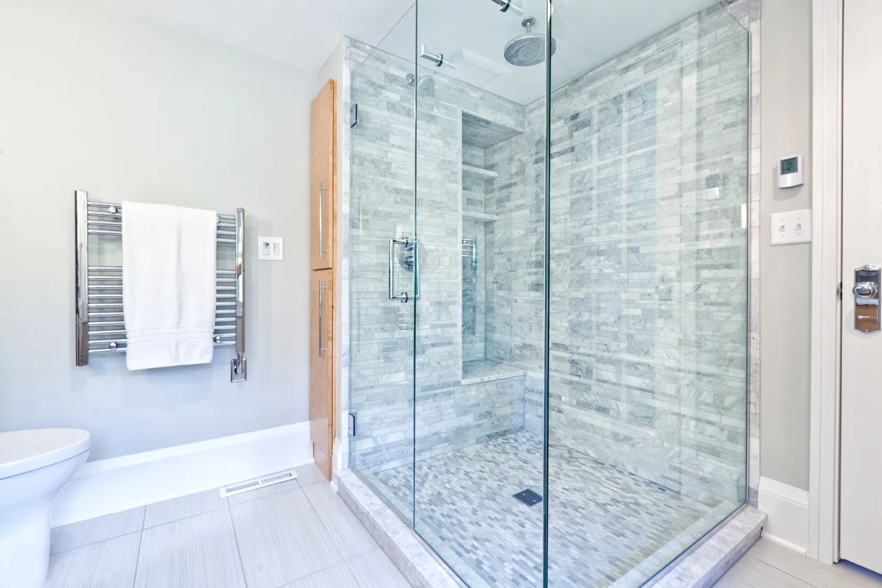 Custom walk-in shower installation with frameless glass and marble tile by Leo Constra in Toronto